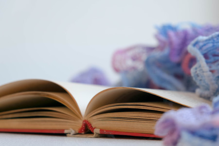Warm and comfy autumn or winter concept. Book, cup of lemon tea and sweater on wooden window sill in old house. Reading and relaxing in cold fall weather at home. Quiet silent homely scene.の写真素材