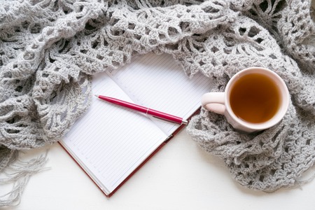 Open notebook and morning cup of tea rustic wooden table top view. Cozy autumn breakfast. Fall bucket list. Flat lay style.の写真素材