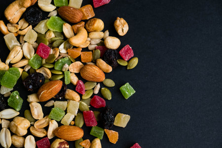 Composition with dried fruits and assorted nuts. Delicacies. Various nuts on stone table. Different...