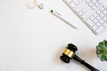 Top view, flat lay. Close up on a white background. copy space for text, selective focus. justice and law concept.Lawyer workplace with laptop and documents with dark woodenの写真素材