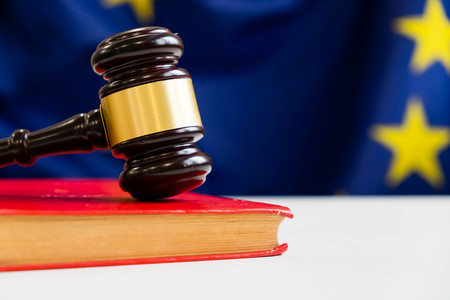 Judges wooden gavel with EU flag in the background. Symbol for jurisdiction. Wooden gavel on european union flagの写真素材