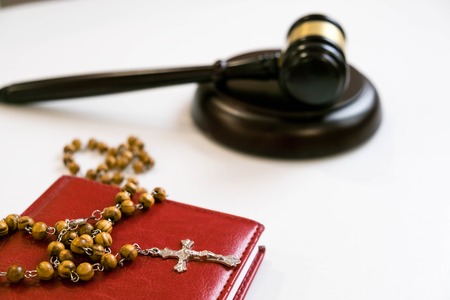 judge's gavel and rosary beads on white backgroundの写真素材