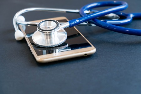 Phone repair and service concept.Smartphone being diagnosed with a stethoscope.の写真素材