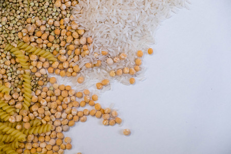 Set of products with complex carbohydrates on white background. wooden spoon, a range of cereals, pasta. Gluten free flour and cereals millet, green buckwheat, basmati rice,up viewの写真素材