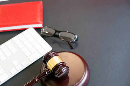 Top view, flat lay. Close up on a black background. copy space for text, selective focus. justice and law concept.Lawyer workplace with laptop and documents with dark woodenの写真素材