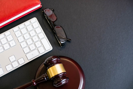 Top view, flat lay. Close up on a black background. copy space for text, selective focus. justice and law concept.Lawyer workplace with laptop and documents with dark woodenの写真素材