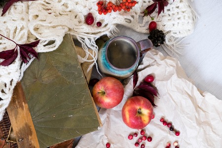 Mug of black coffee wrapped in warm scarf on wooden board. Top view, vintage style, Still life.の写真素材