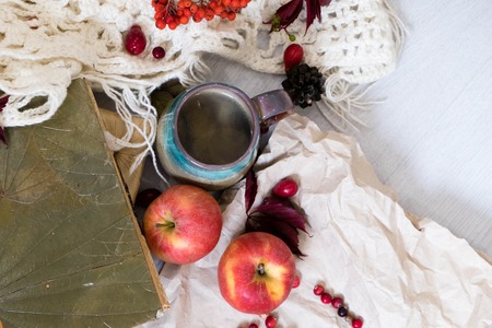 Mug of black coffee wrapped in warm scarf on wooden board. Top view, vintage style, Still life.の写真素材