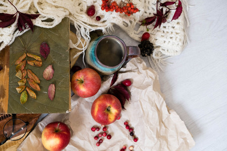 Mug of black coffee wrapped in warm scarf on wooden board. Top view, vintage style, Still life.の写真素材