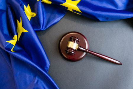 Judges wooden gavel with EU flag in the background. Symbol for jurisdiction. Wooden gavel on european union flagの写真素材