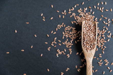 Flax seeds in spoons over dark background. Natural light. Selective focus. Close up on a black background. Top view, flat lay. copy spaceの写真素材