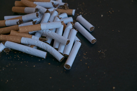 broken scattered cigarettes, tobacco, close-up on a black background. Top view with copy space, flat lay. STOP Smoking. World no tobacco day.の写真素材