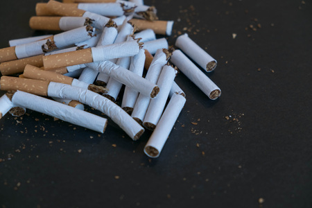 broken scattered cigarettes, tobacco, close-up on a black background. Top view with copy space, flat lay. STOP Smoking. World no tobacco day.の写真素材
