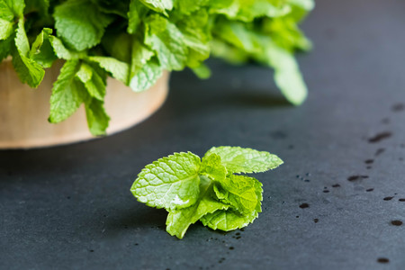 mint leaf. Green fresh mint, selective focus. Bunch of Fresh green organic mint leaf closeup. Peppermint. Natural light. Selective focus. Close up on a black background. Top view, flat lay. copy spaceの写真素材