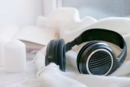 The laptop working and listen music on the white bed and coffee with marshmallow, warm knitted sweater in the sunny day. Cozy winter home morning holiday. Music and Lifestyle Concept.の写真素材