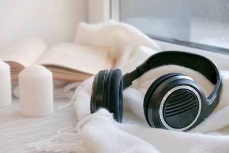 The laptop working and listen music on the white bed and coffee with marshmallow, warm knitted sweater in the sunny day. Cozy winter home morning holiday. Music and Lifestyle Concept.の写真素材
