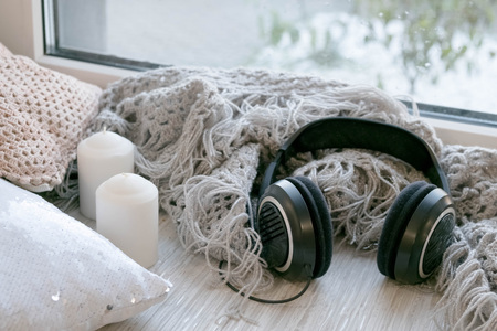 The laptop working and listen music on the white bed and coffee with marshmallow, warm knitted sweater in the sunny day. Cozy winter home morning holiday. Music and Lifestyle Concept.の写真素材