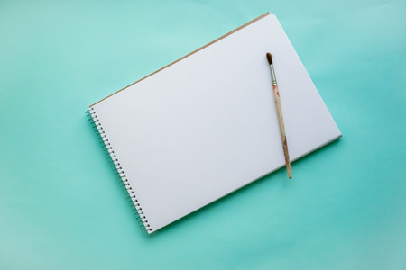 An empty sheet of sketchbook or album for drawing on a pink, blue background. Drawing a still life. Flat lay stock photo. Creativity conceptの写真素材