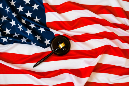 Wooden judge gavel and soundboard laying over US flag. Hammer and gavel. American law and justice concept. bidding concept.の写真素材