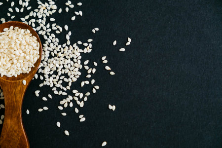 Organic natural sesame seeds wooden spoon. toasted sesame seeds. Raw, whole, unprocessed. Natural...
