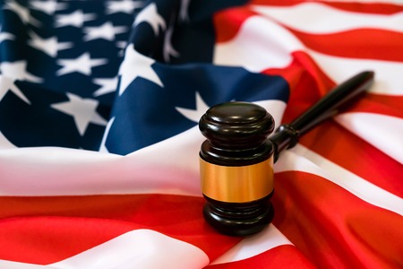 Wooden judge gavel and soundboard laying over US flag. Hammer and gavel. American law and justice concept. bidding concept.の写真素材