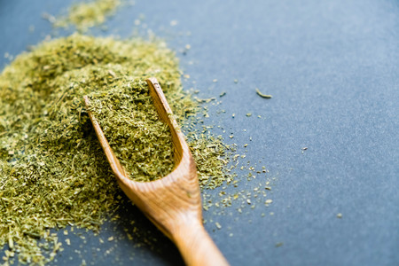 Dried oregano herbs in wooden spoon. Natural light. Selective focus. Close up on a black background. Top view, flat lay. copy space.の写真素材