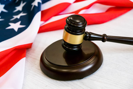 Wooden judge gavel and soundboard laying over US flag. Hammer and gavel. American law and justice concept. bidding concept.の写真素材