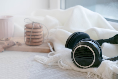 cozy winter still life: warm woolen knitting, hot tea, red book, Christmas cookies and music. Headphones. Hygge style. Cozy winter home morning holiday. Soft photoの写真素材