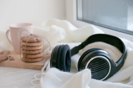 cozy winter still life: warm woolen knitting, hot tea, red book, Christmas cookies and music. Headphones. Hygge style. Cozy winter home morning holiday. Soft photoの写真素材