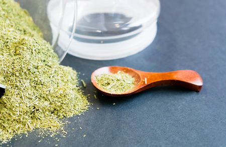 Dried oregano herbs in wooden spoon. Natural light. Selective focus. Close up on a black background. Top view, flat lay. copy space.の写真素材