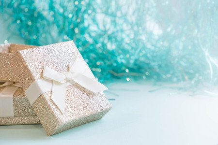 Open empty gift box with blue ribbon, confetti and ballsの写真素材