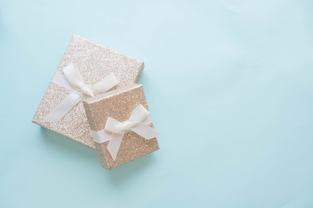 Present with red bow on pink background with tittle sparkles. Flat lay trendy style.の写真素材
