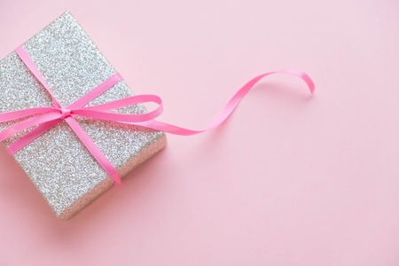 Christmas gift gold box on a pink background. Holiday greeting card. New Year, holidays and celebration concept. Top view, flat lay. Close up. copy space for text, selective focusの写真素材