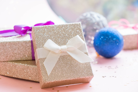 Gold gift box and a small Bell tied a red bo lay on the wood White and pine Christmas dayの写真素材