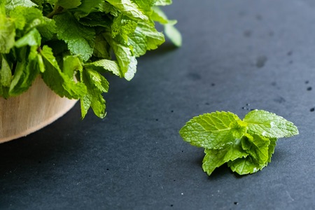 mint leaf. Green fresh mint, selective focus. Bunch of Fresh green organic mint leaf closeup. Peppermint. Natural light. Selective focus. Close up on a black background. Top view, flat lay. copy spaceの写真素材