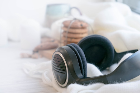 cozy winter still life: warm woolen knitting, hot tea, red book, Christmas cookies and music. Headphones. Hygge style. Cozy winter home morning holiday. Soft photoの写真素材