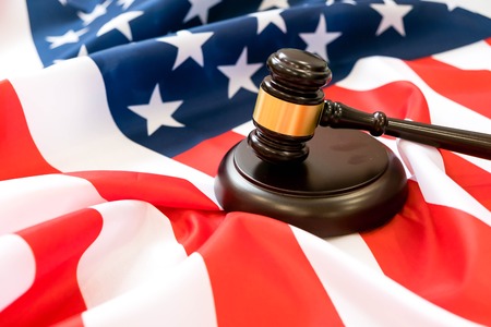 Wooden judge gavel and soundboard laying over US flag. Hammer and gavel. American law and justice concept. bidding concept.の写真素材