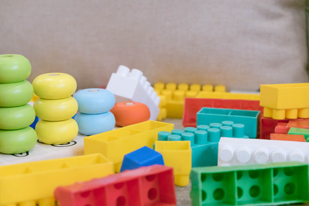 Top view on colorful toy bricks on a white wooden background. Toys in the tableの写真素材