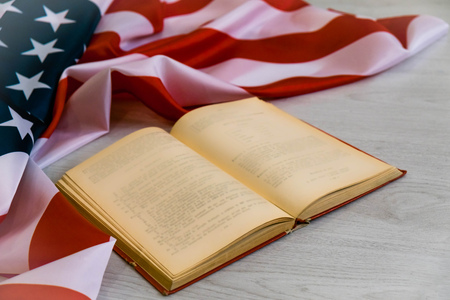 Opened book and USA flag. US flag behind a book. Education is power. You should know your rights.の写真素材