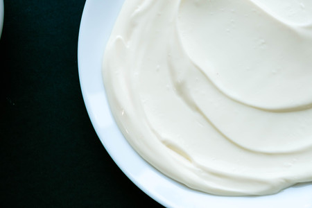 close up of a white whipped or sour cream on white backgroundの写真素材