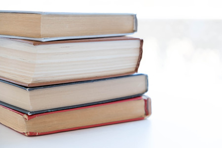 Book stack in the library room and blurred bookshelf, business and education backgroundの写真素材