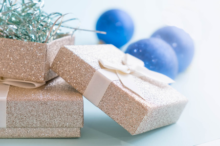 Gold gift box and a small Bell tied a red bo lay on the wood White and pine Christmas dayの写真素材
