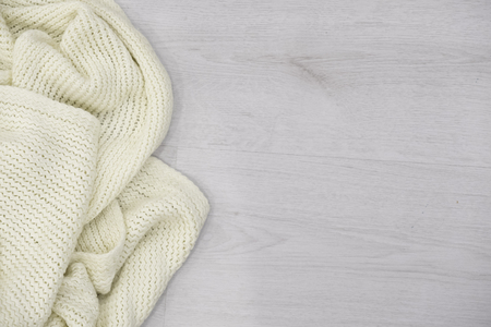 Cozy soft plaid on white wooden background. winter knitted sweater old vintage wooden board. Christmas holidays at home. place for text, Top view flat lay with copy space for slogan or textの写真素材
