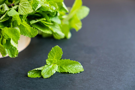 mint leaf. Green fresh mint, selective focus. Bunch of Fresh green organic mint leaf closeup. Peppermint. Natural light. Selective focus. Close up on a black background. Top view, flat lay. copy spaceの写真素材