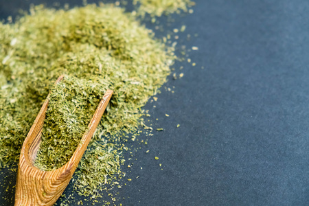 Dried oregano herbs in wooden spoon. Natural light. Selective focus. Close up on a black background. Top view, flat lay. copy space.の写真素材