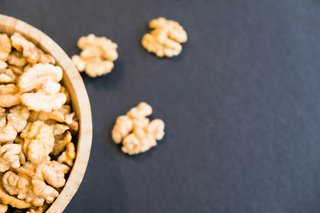 Whole Walnuts and Cleared Black Wooden Background Top view Healthy concept. Natural light. Selective focus. Close up on a black background. Top view, flat lay. copy spaceの写真素材
