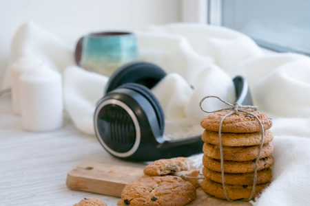 cozy winter still life: warm woolen knitting, hot tea, red book, Christmas cookies and music. Headphones. Hygge style. Cozy winter home morning holiday. Soft photoの写真素材