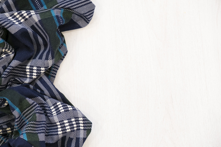 Flat lay of scarf with Christmas tartan texture and branch of tree on wooden background with space in middle - Christmas or New Year backgroundの写真素材