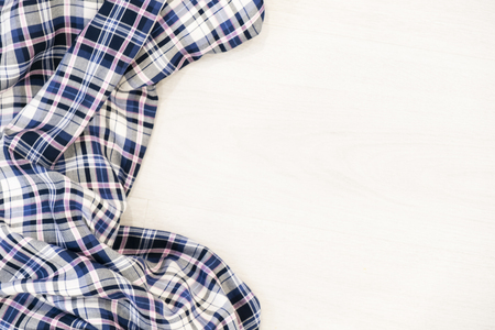Flat lay of scarf with Christmas tartan texture and branch of tree on wooden background with space in middle - Christmas or New Year backgroundの写真素材