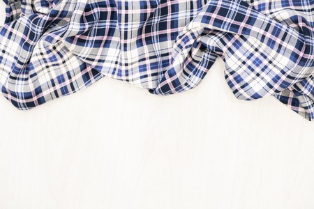 Flat lay of scarf with Christmas tartan texture and branch of tree on wooden background with space in middle - Christmas or New Year backgroundの写真素材